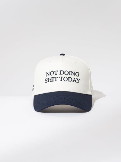 ["Day Off Trucker Hat ", " White and Navy ", " Product Image ", " Uncommon Lifestyle "]