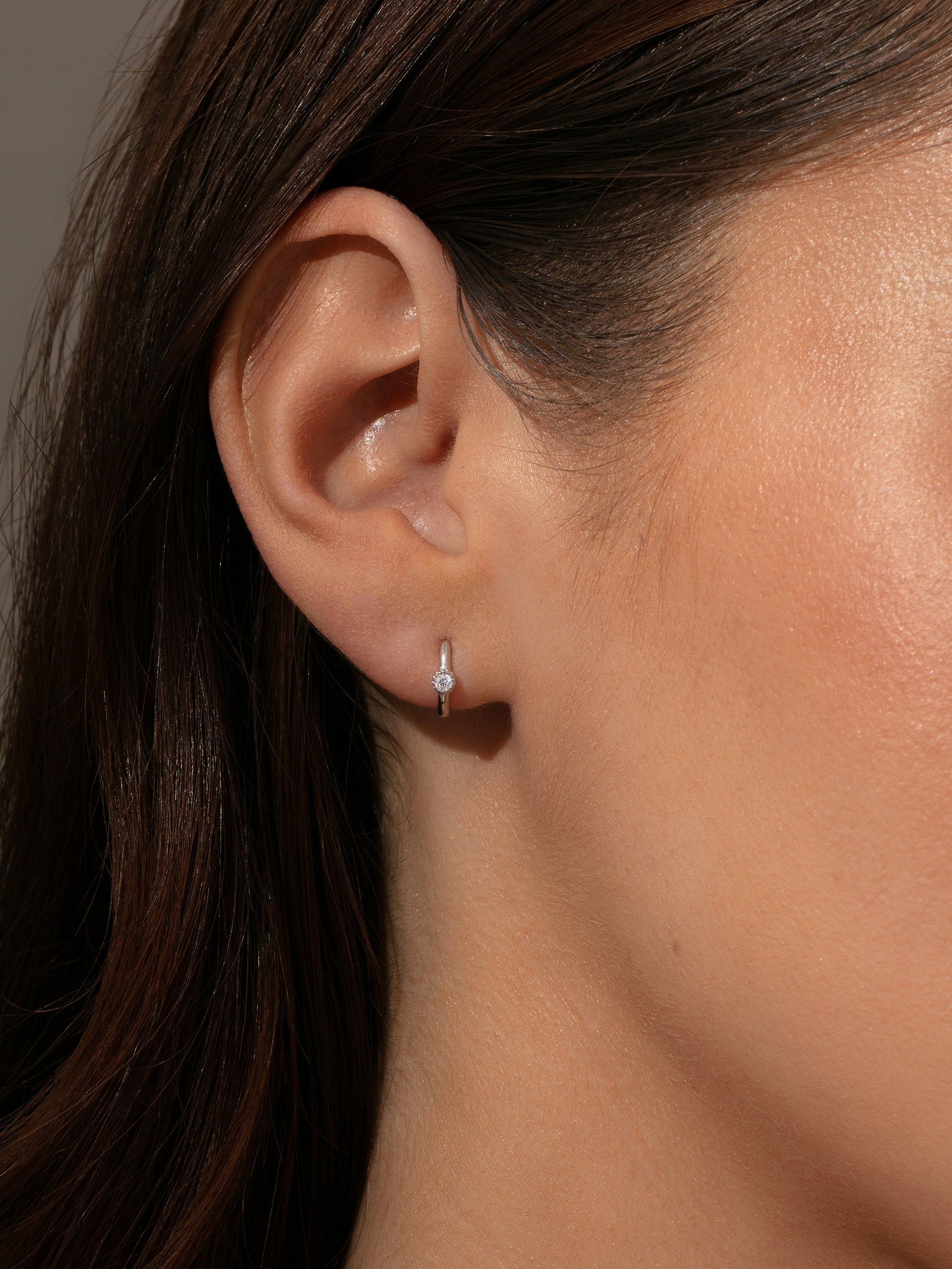 Center Stage Huggie Earrings | Sterling Silver Clear | Model Image | Uncommon James
