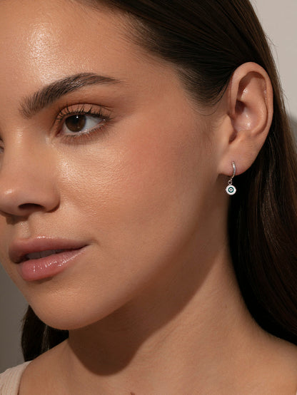 ["Simple Evil Eye Huggie Earrings ", " Silver ", " Model Image ", " Uncommon James"]