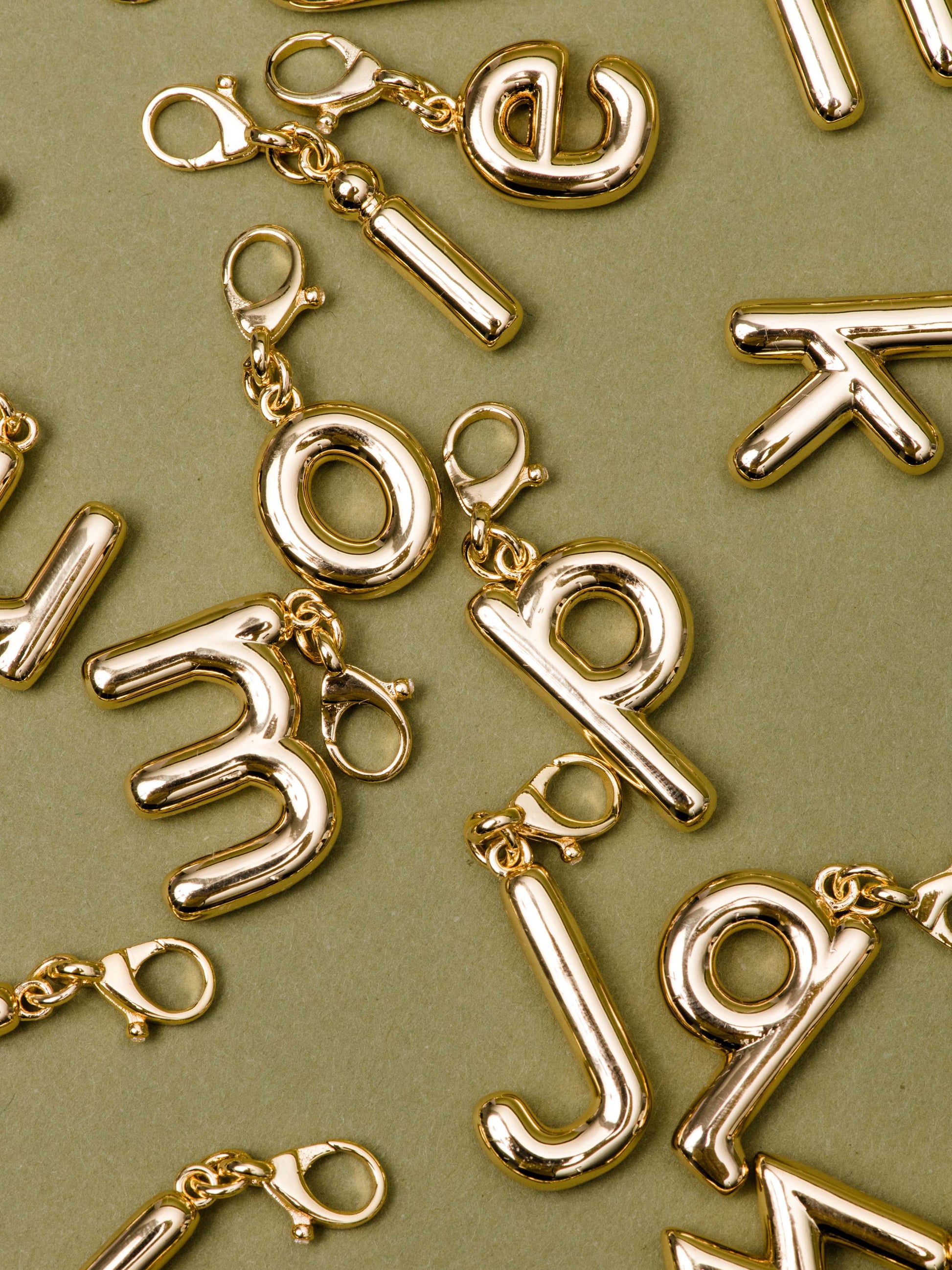 Bubble Letter Charm | Gold | Flatlay Image | Uncommon James